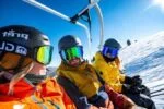 personnes avec des casques sur un télésiege, au ski.