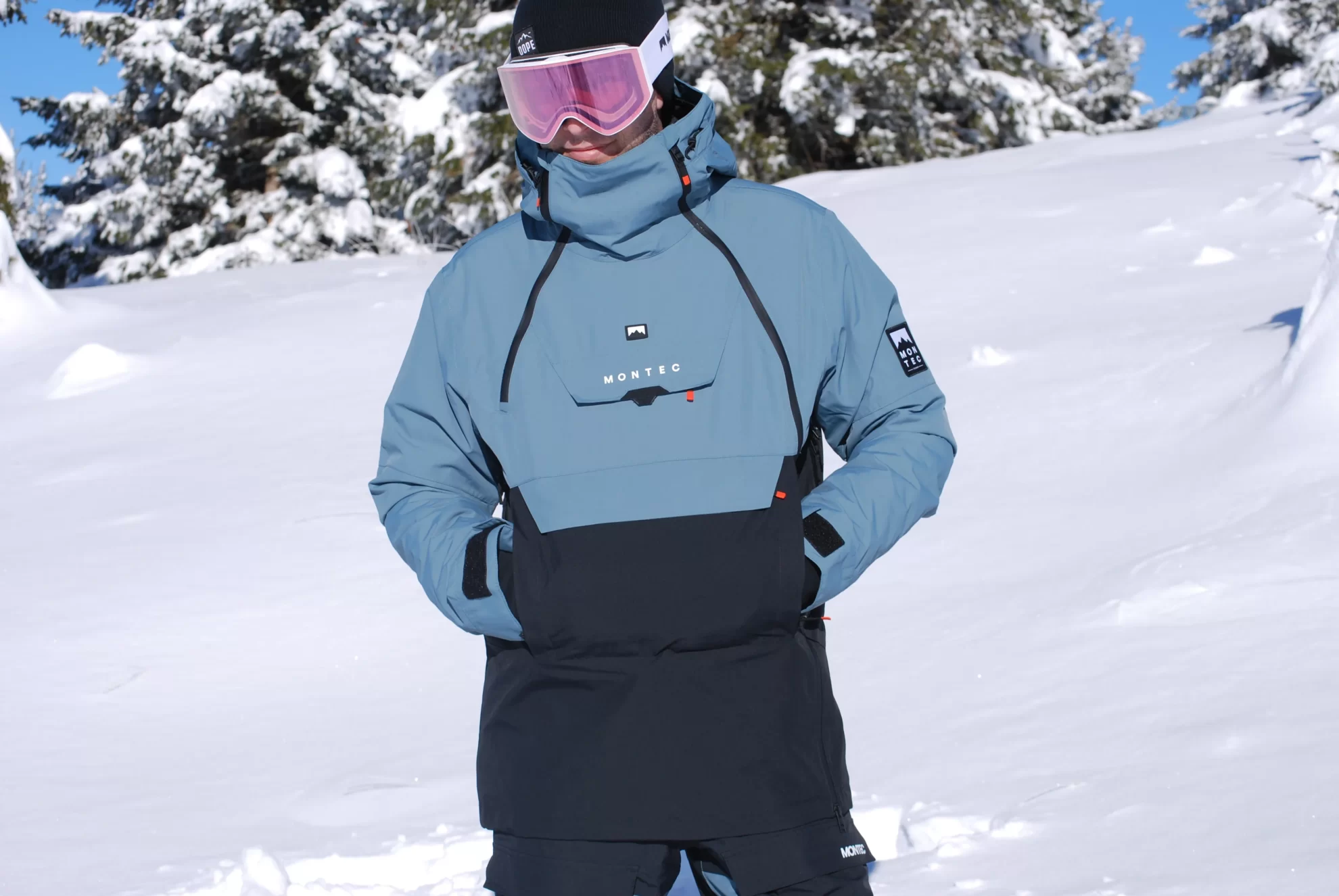Skieur regardant devant lui avec la veste de ski et les mains dans les poches.