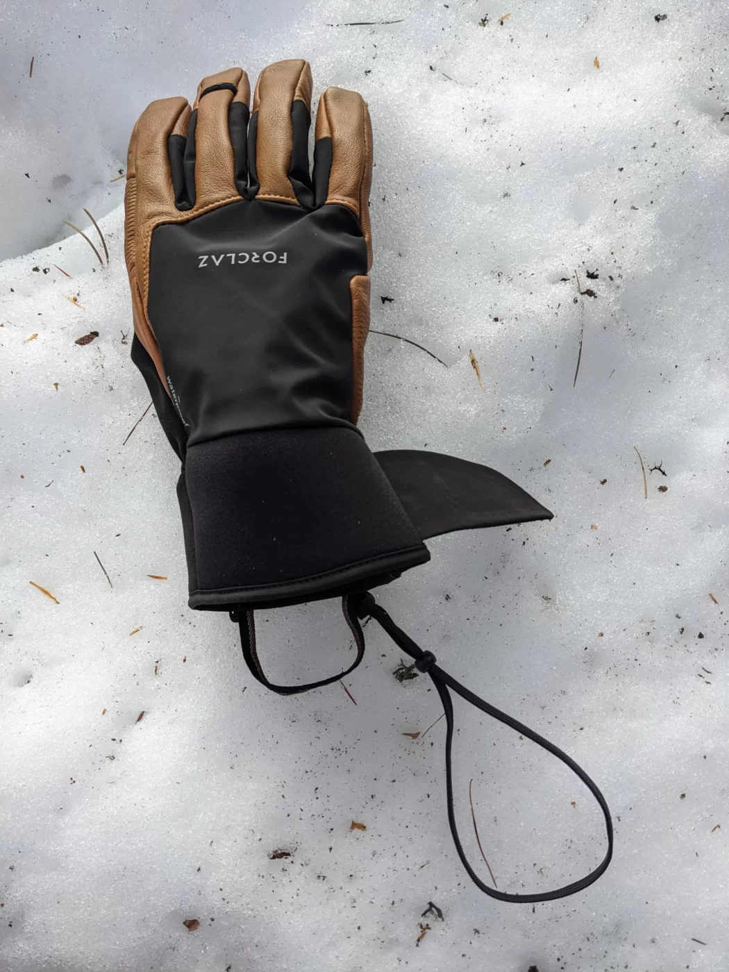 gants dans la neige avec les lanières exposées
