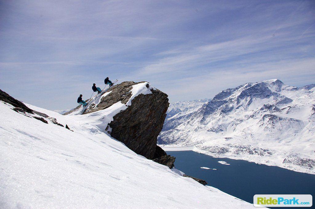 Une séquence de ski sur un gros rocher avec le lac du Mont Cenis en contre-bas